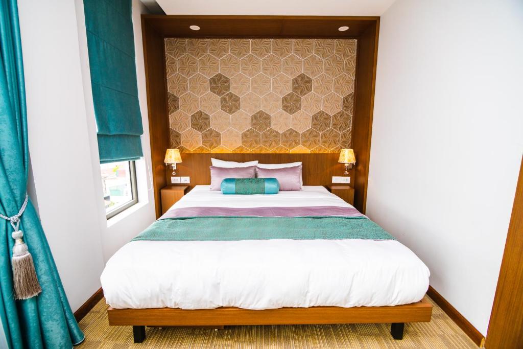 河内HANA Stay的一间卧室配有一张大床和木制床头板