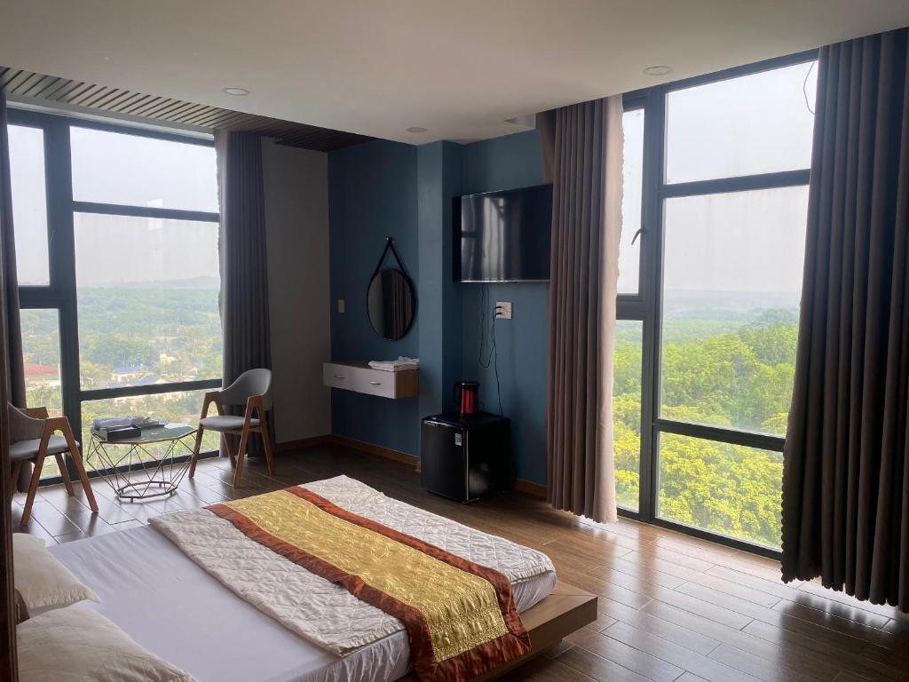 Thanh BìnhHotel Stylish Binh Long的一间卧室设有一张蓝色的墙壁和大窗户。