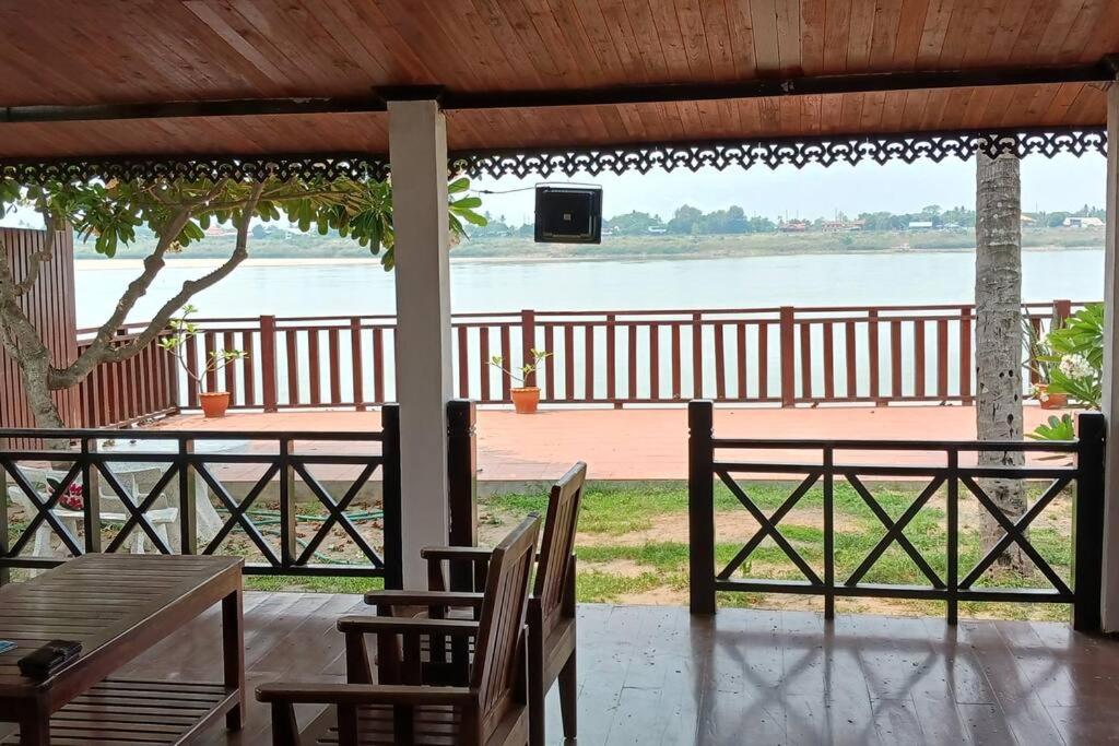 万象MEKONG VIEW VILLE的一个带桌椅的庭院,享有水景