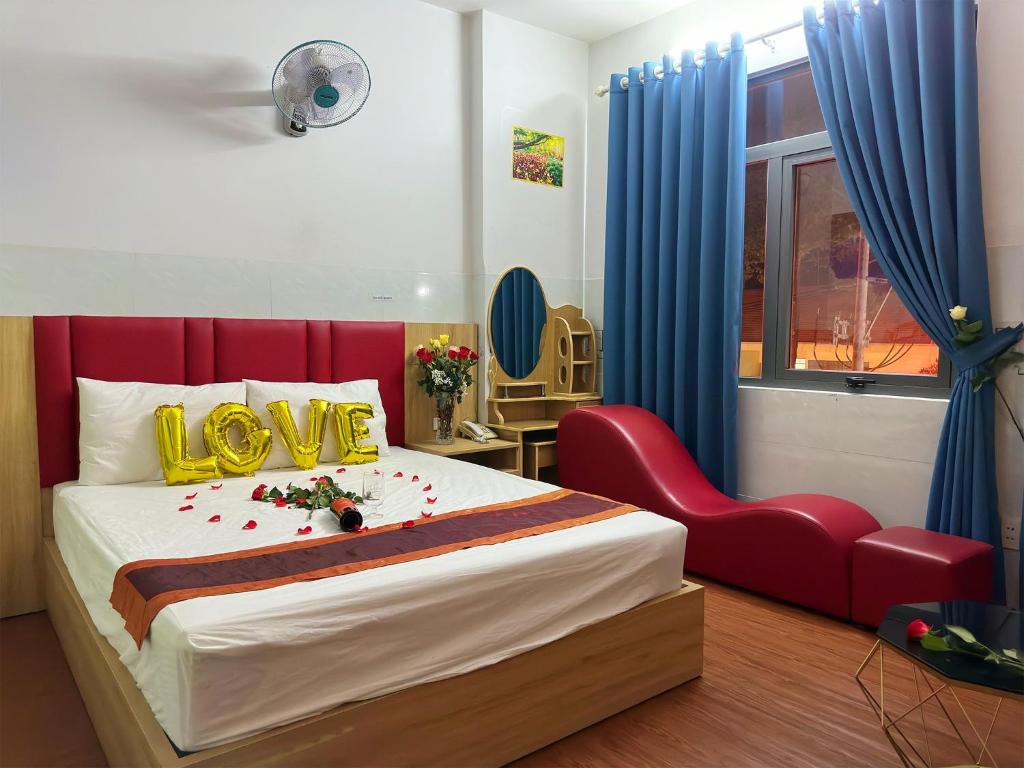 胡志明市Khách Sạn Nguyên Trung的一间卧室配有红色的床和红色椅子