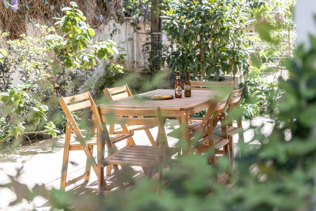 特拉维夫Heart of Tel Aviv Garden Oasis by Sea N' Rent的一张带椅子的木桌和两瓶啤酒