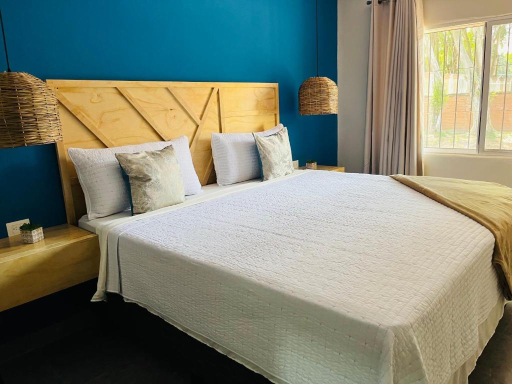 La LimaWE Hotel, La Lima的一间卧室配有一张带蓝色墙壁的大床