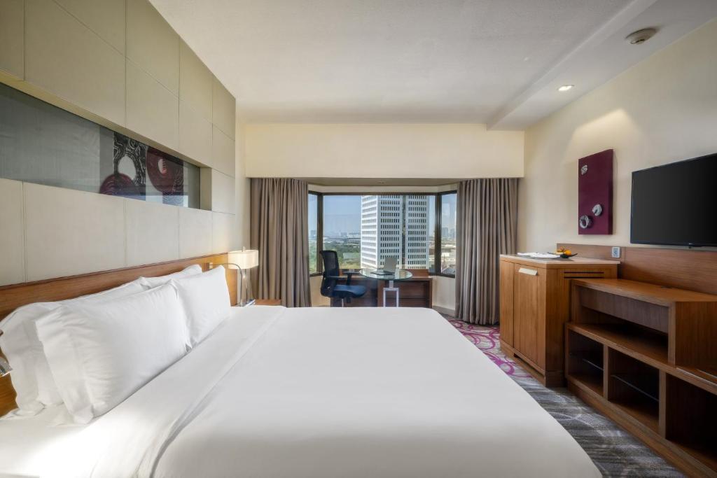 曼谷盛泰澜曼谷拉普崂中央广场酒店的酒店客房,配有床和电视