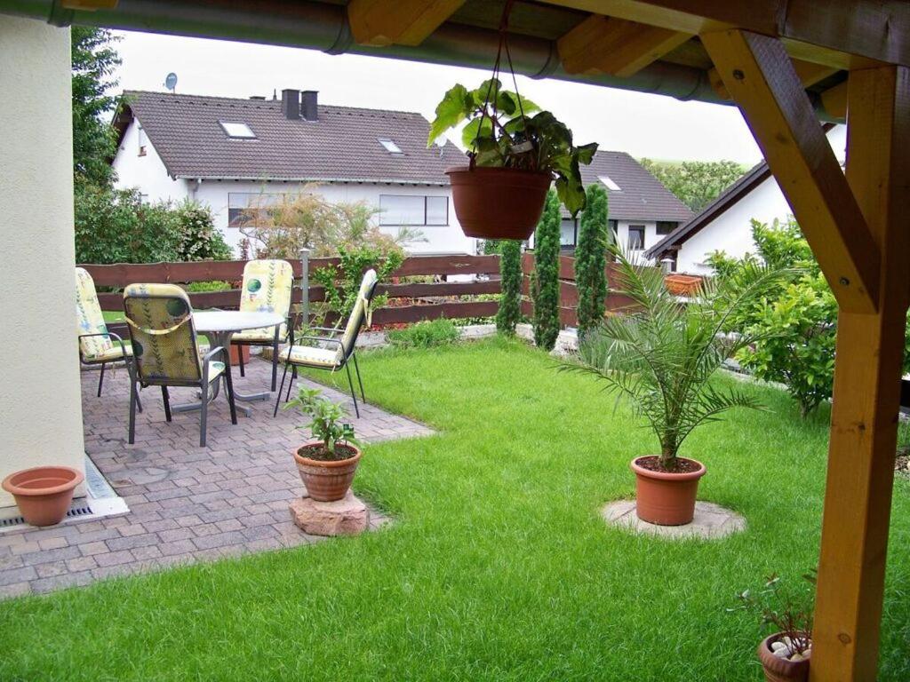 Holiday apartment oasis的庭院配有桌椅和植物