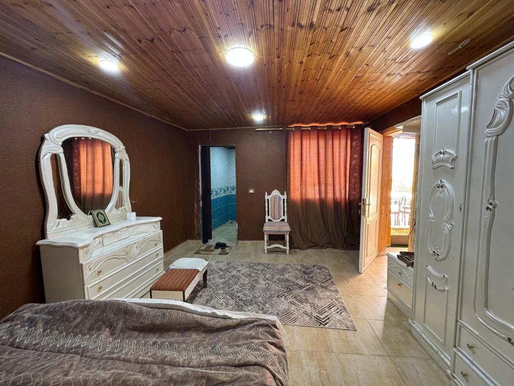 Al Ramaشاليه البحر الميت الرامة-Deadsea的一间卧室配有一张床、梳妆台和镜子