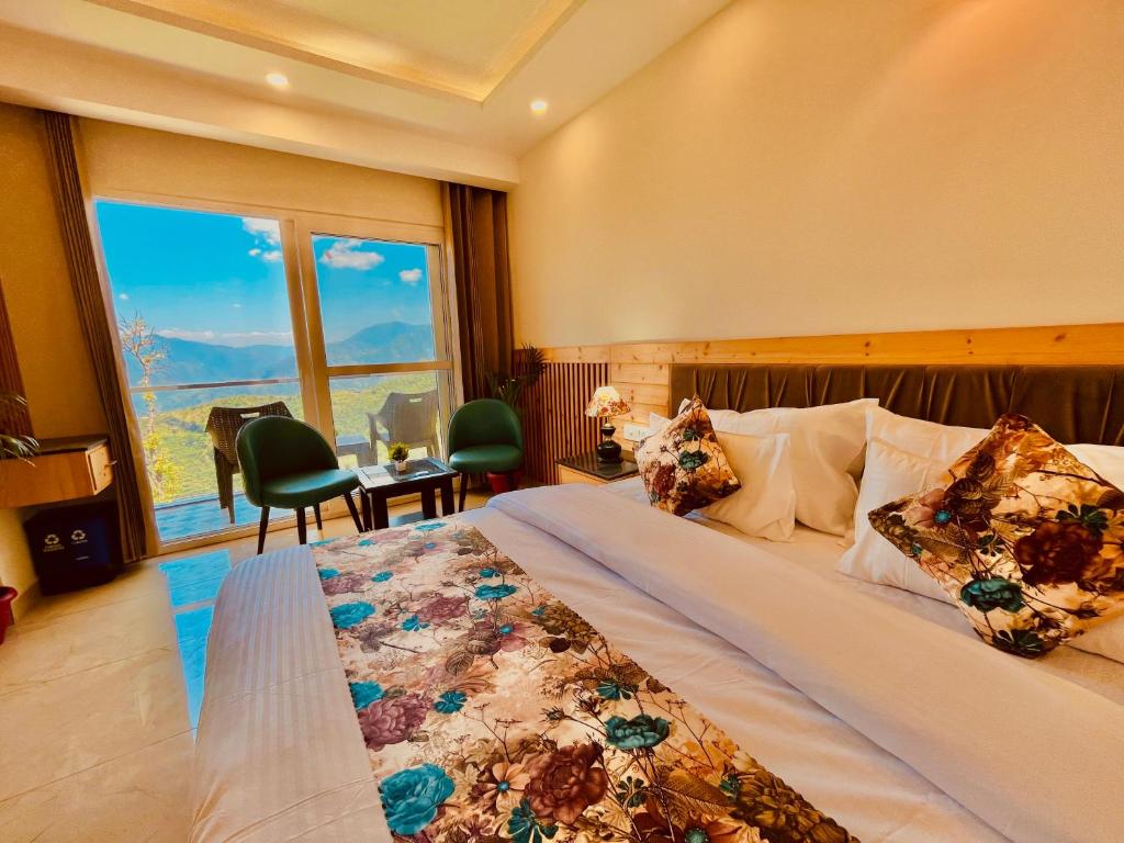 穆索里The Pine Woods - A Four Star Luxury Resort in Mussoorie的一间卧室设有一张大床和一个大窗户