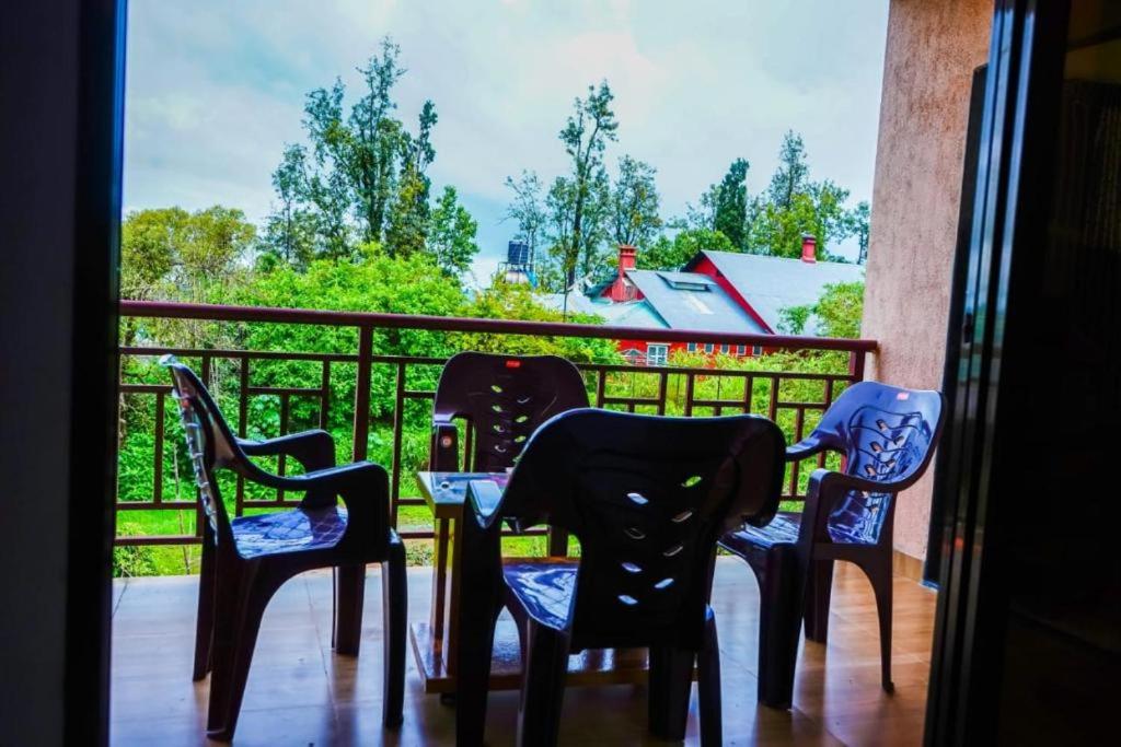 潘奇加尼HOTEL SAMRUDDHI的美景阳台配有四把椅子和一张桌子