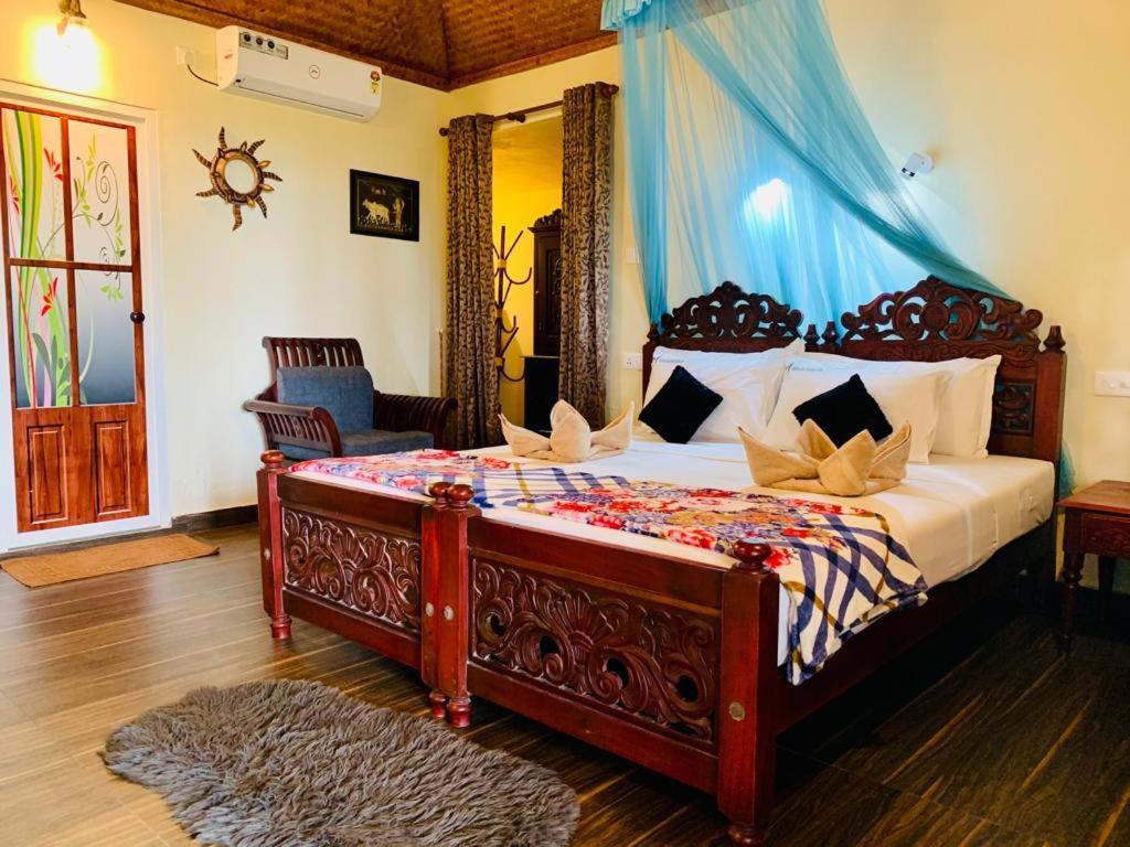 瓦尔卡拉Maadathil Beach Resort的一间卧室配有一张蓝色天蓬大床
