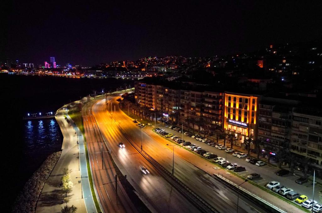 伊兹密尔The Yalı Konak Hotel İzmir的街道,夜间有汽车和建筑