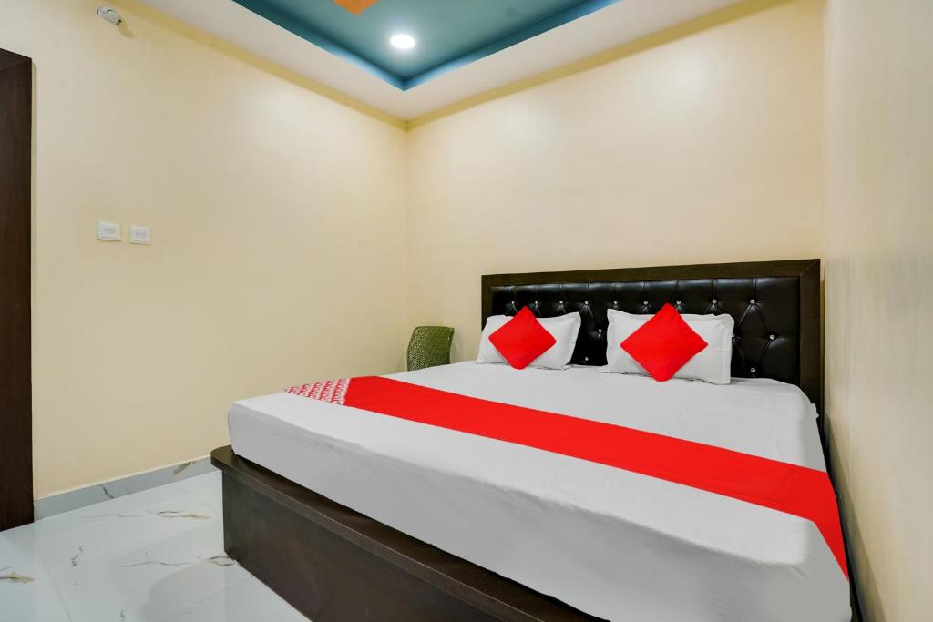 ItwāriOYO Flagship Heritage Farm Resort的一间卧室配有一张带红色枕头的大床
