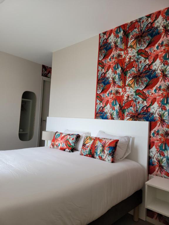 基伯龙波特哈利甘酒店的卧室配有白色床和花卉壁纸