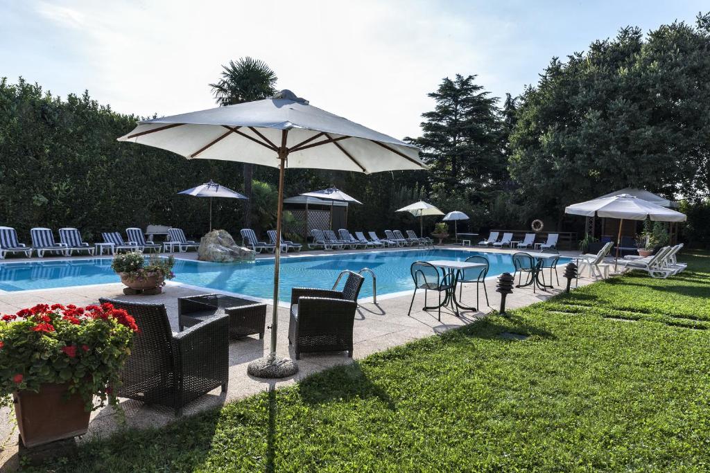 卡塞勒蒂索玛坎普Hotel Saccardi & Spa - Adults Only的一个带桌椅和遮阳伞的游泳池