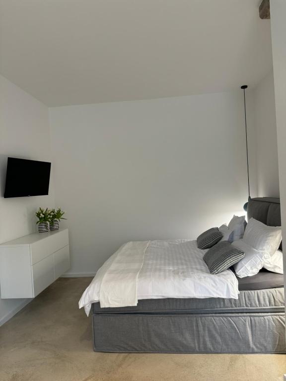 维岑多夫Sievershof Strandbar的一间白色卧室,配有床和电视