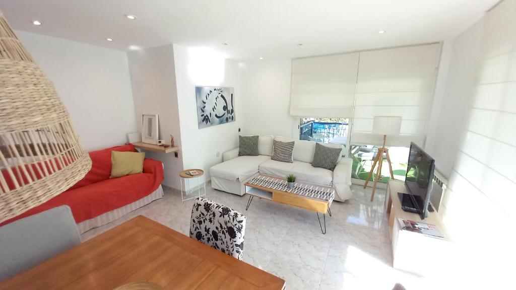 马斯诺Bell Resguard near beach & Barcelona 20 min的客厅配有红色和白色的沙发以及电视。