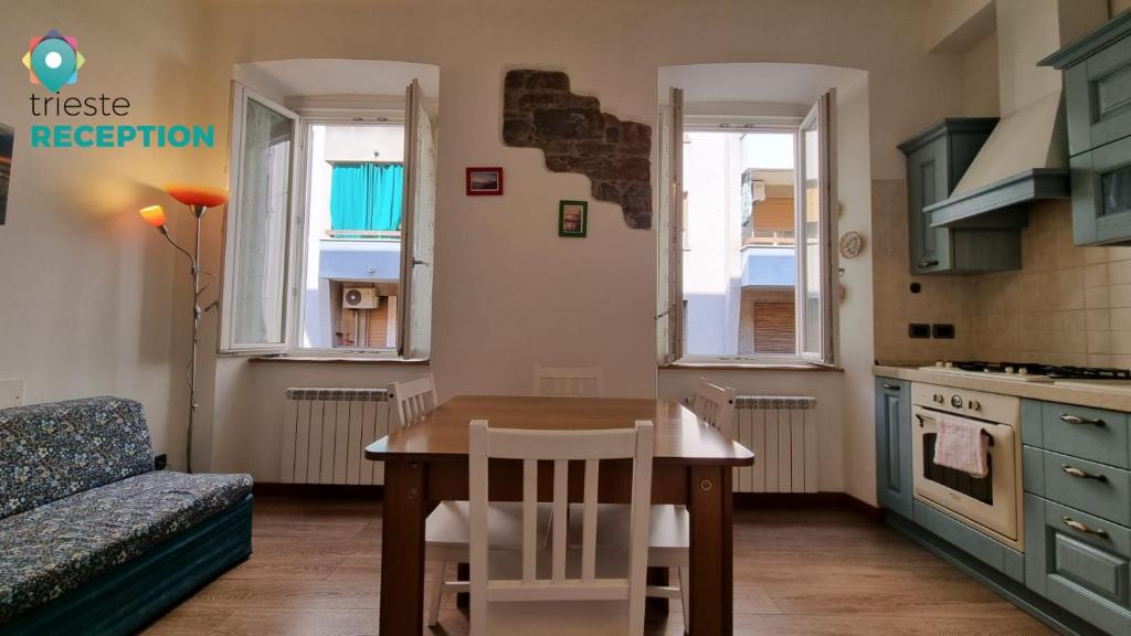 的里雅斯特Ex Lavatoio 3的厨房配有桌子、沙发、桌子和椅子