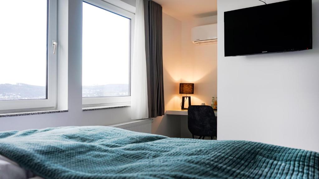 锡根SI-View Doppelzimmer mit Stadtblick Zimmer 21的一间卧室配有一张床和一台平面电视
