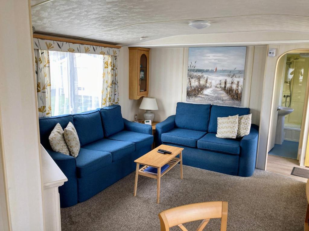 斯凯格内斯Sea Breeze at Winthorpe Skegness的客厅配有蓝色的沙发和桌子