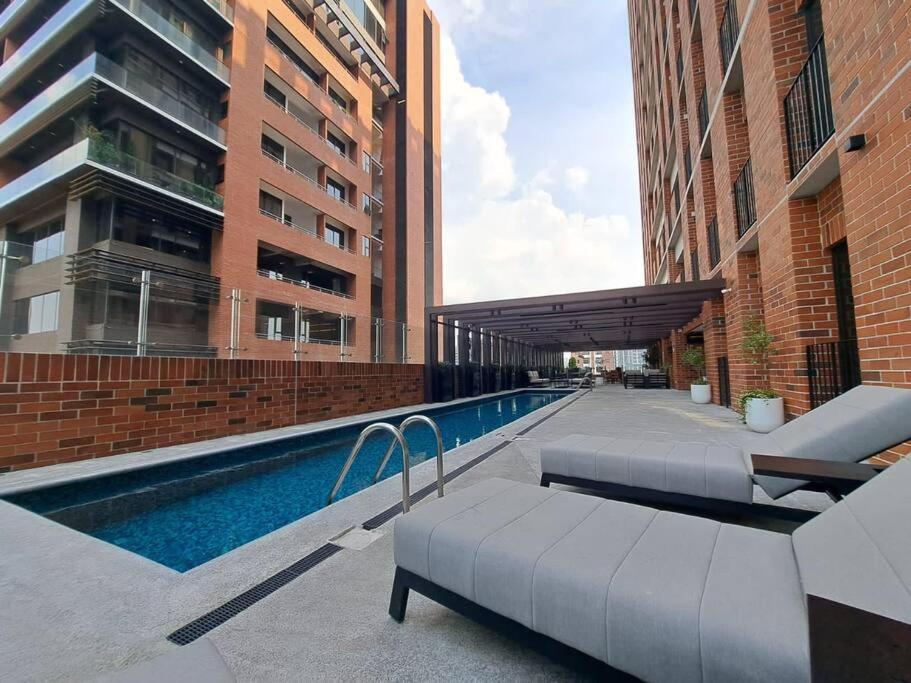 危地马拉Hemen - Luxury Apartment with pool的一座游泳池,毗邻一些高楼
