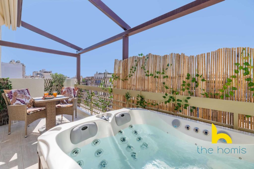 雅典Athenian Sky Retreat: Jacuzzi & Fresh Elegance!的房屋阳台的按摩浴缸