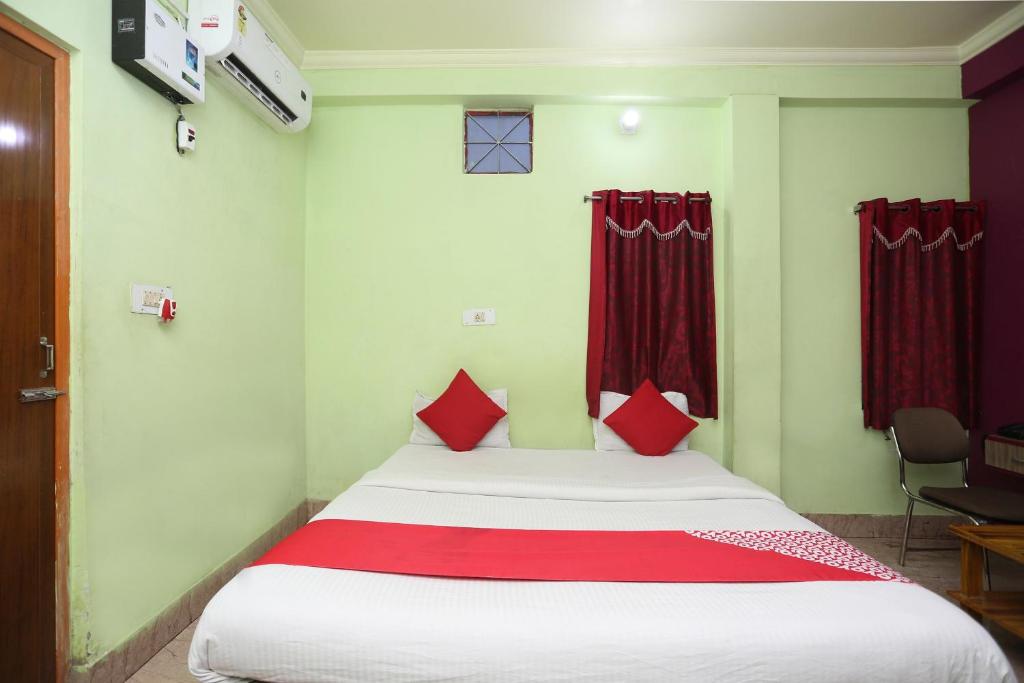 布巴内什瓦尔OYO Near Kalinga Hospital的一间卧室配有一张带红色窗帘的大床