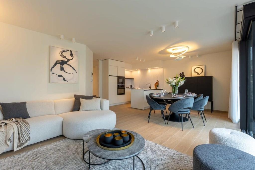 德帕内Modern apartment located on the square of De Panne的客厅配有白色的沙发和桌子
