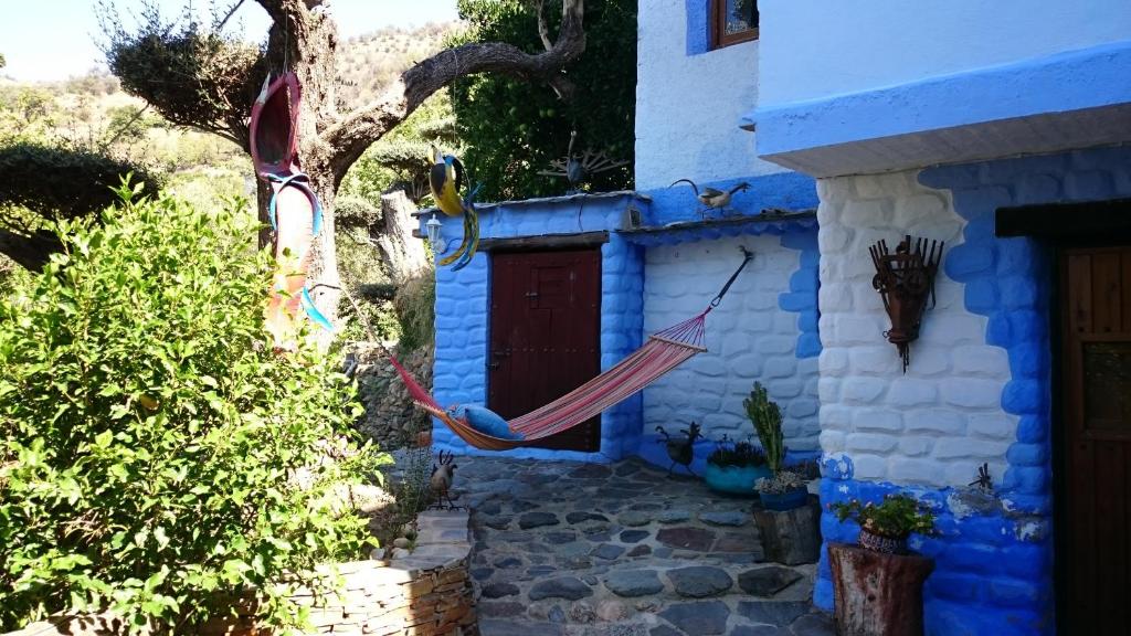 兰哈龙布兰扎尔乡村公寓的蓝色房子前面设有吊床