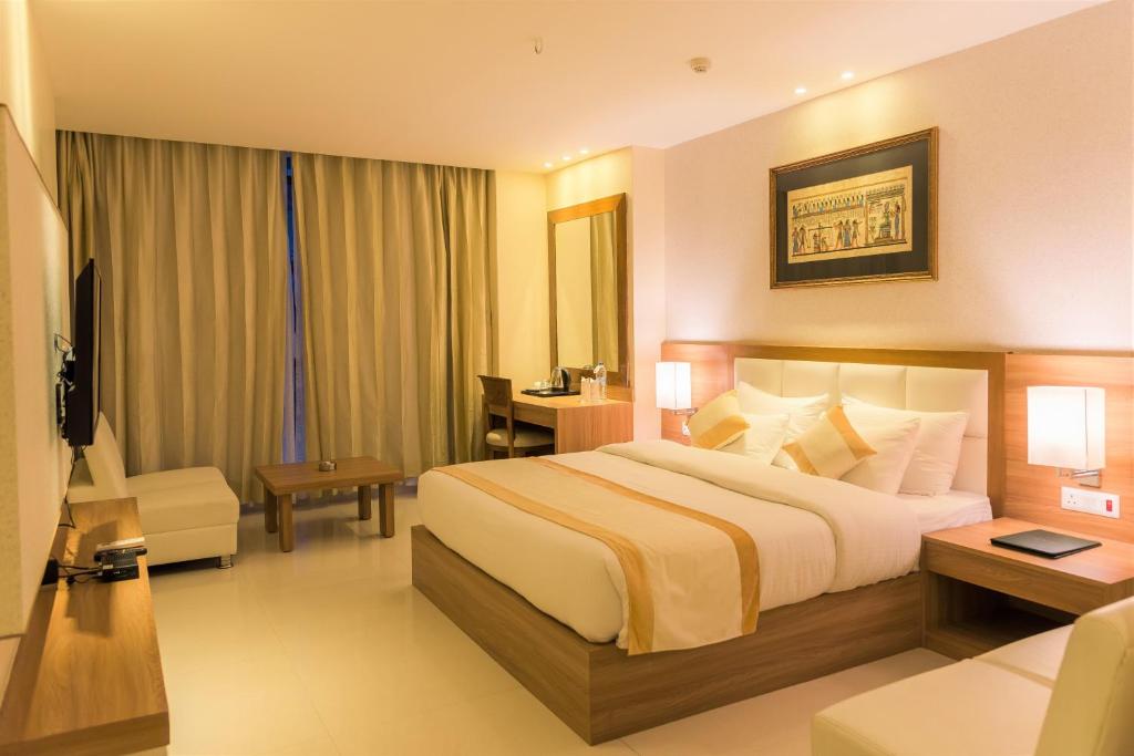 因帕尔三爱大陆精品酒店的酒店客房设有一张大床和一张书桌。