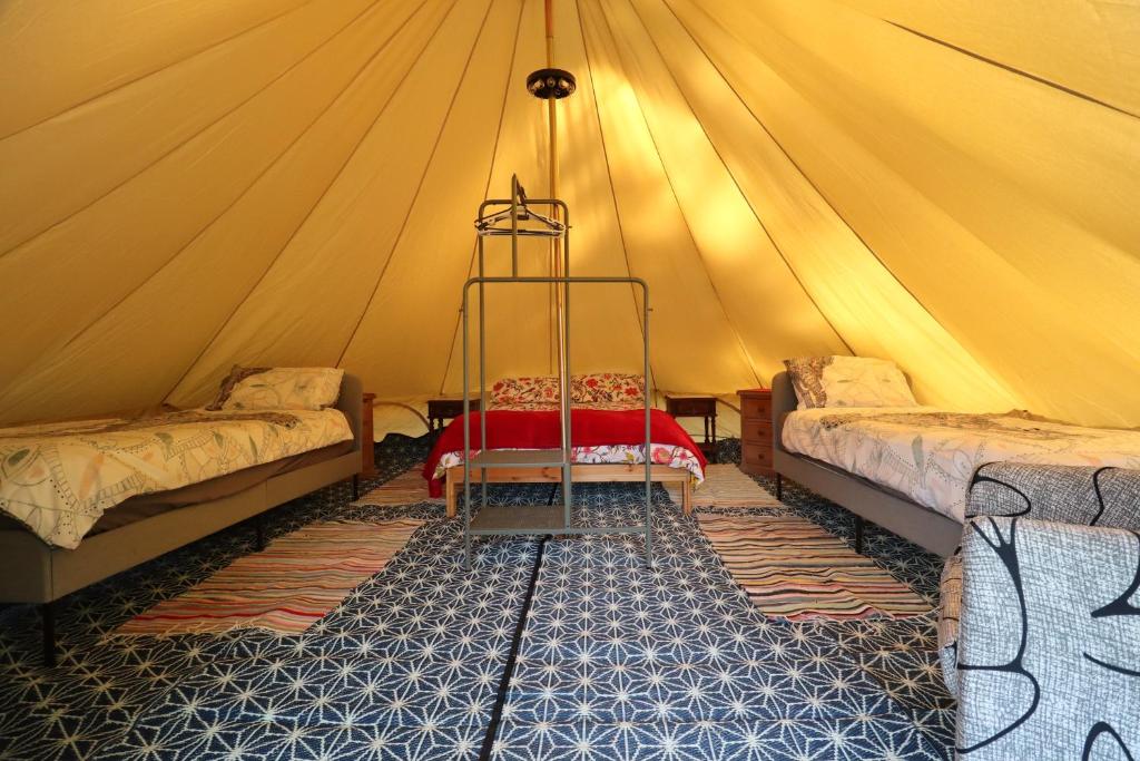 塔布阿glamping with private solar heated swimming pool的帐篷配有两张床和秋千