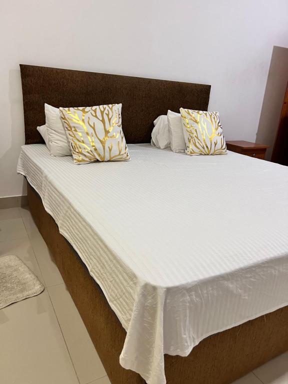 拉维尼亚山R&R residencies的一张配有白色床单和枕头的大床