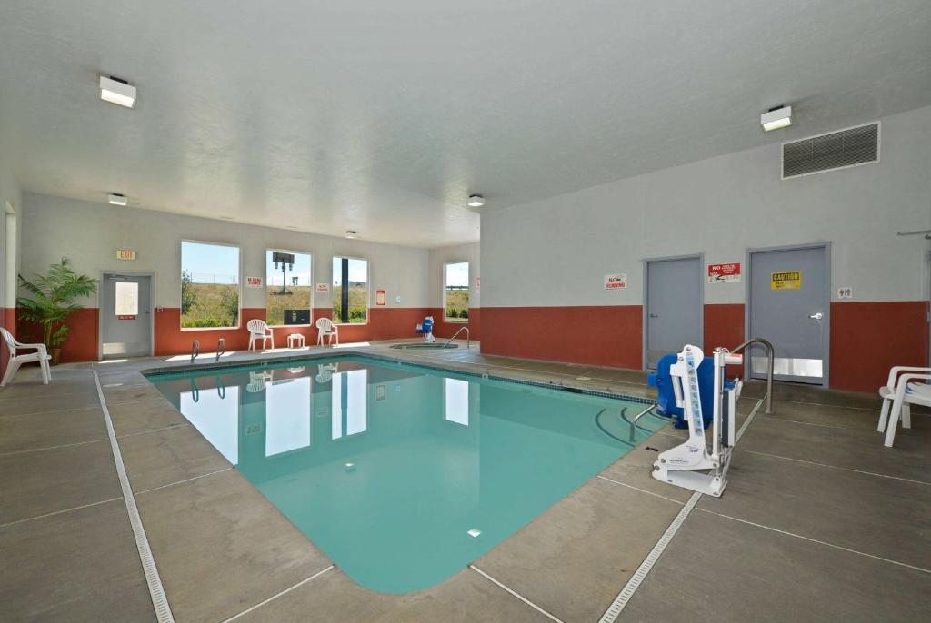 罗斯堡罗斯堡速8酒店的一个带桌椅的健身房内的游泳池