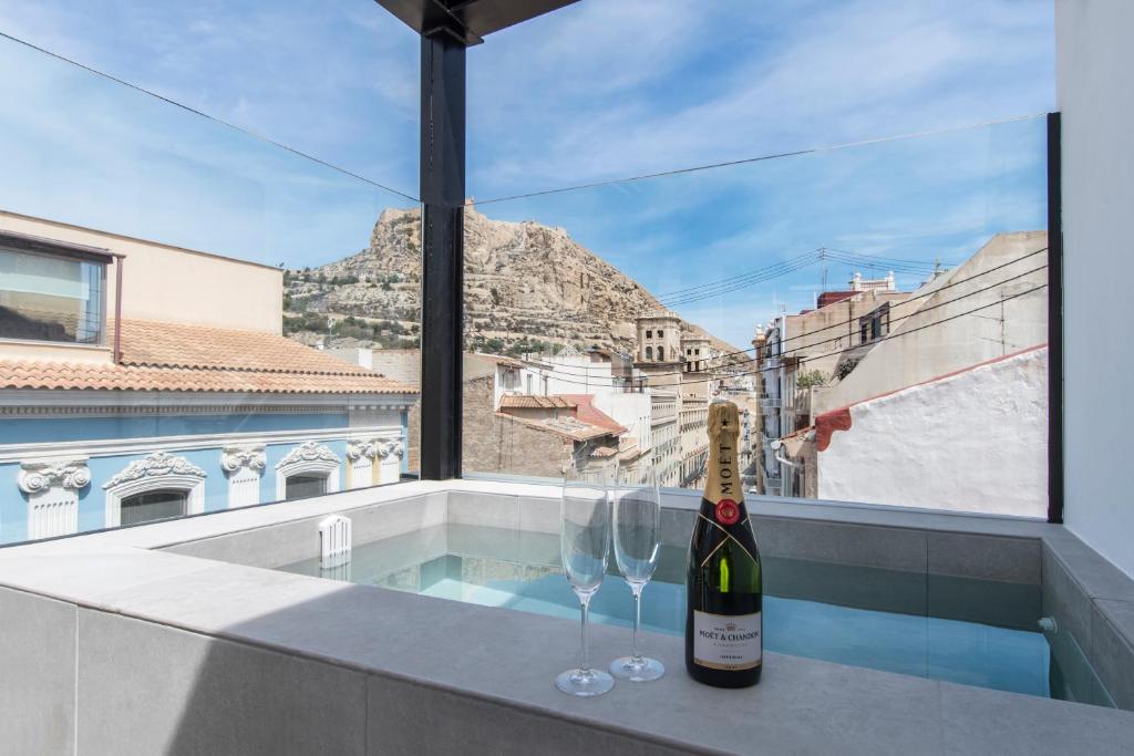 阿利坎特RS Boutique Apartments的阳台上的一瓶葡萄酒和两杯酒