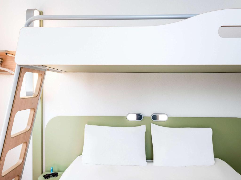 翁弗勒尔翁弗勒尔中心宜必思快捷酒店的一间卧室配有双层床和2个枕头