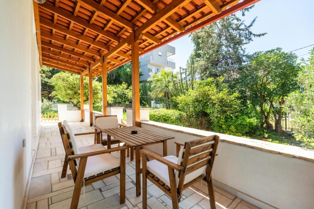 雅典Athenian 2BR Cottage with Garden & BBQ near Metro的庭院配有木桌和椅子