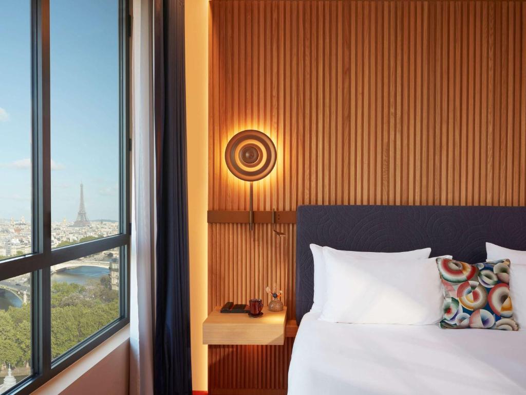 巴黎SO/ Paris Hotel的一间卧室设有一张床和一个大窗户