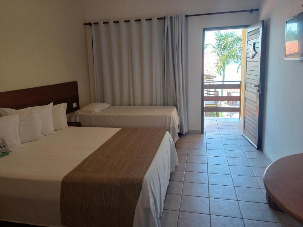 圣若泽-达科罗阿格兰迪Pousada Vivenda Oriente的酒店客房设有两张床和一个阳台。