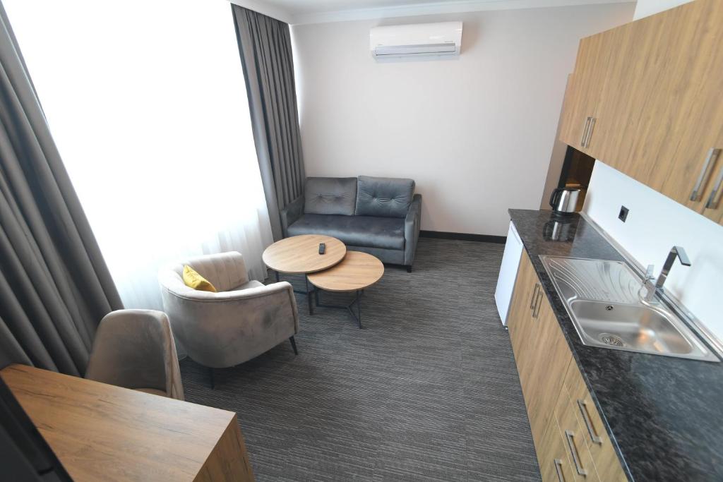 伊斯坦布尔VPLUS HOTEL的小房间设有桌子、沙发和桌子