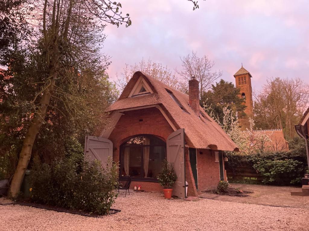 瓦瑟纳尔Cottage Guest House in Wassenaar的一间棕色屋顶的小房子