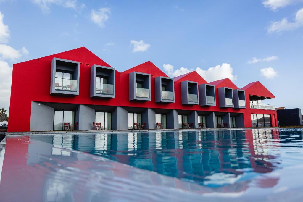 Areia LargaPico Terramar & SPA的游泳池旁的红色建筑