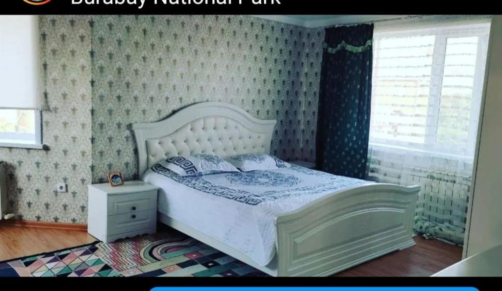 博罗沃耶Гостевой дом Jasmine的卧室设有一张白色大床和一扇窗户。