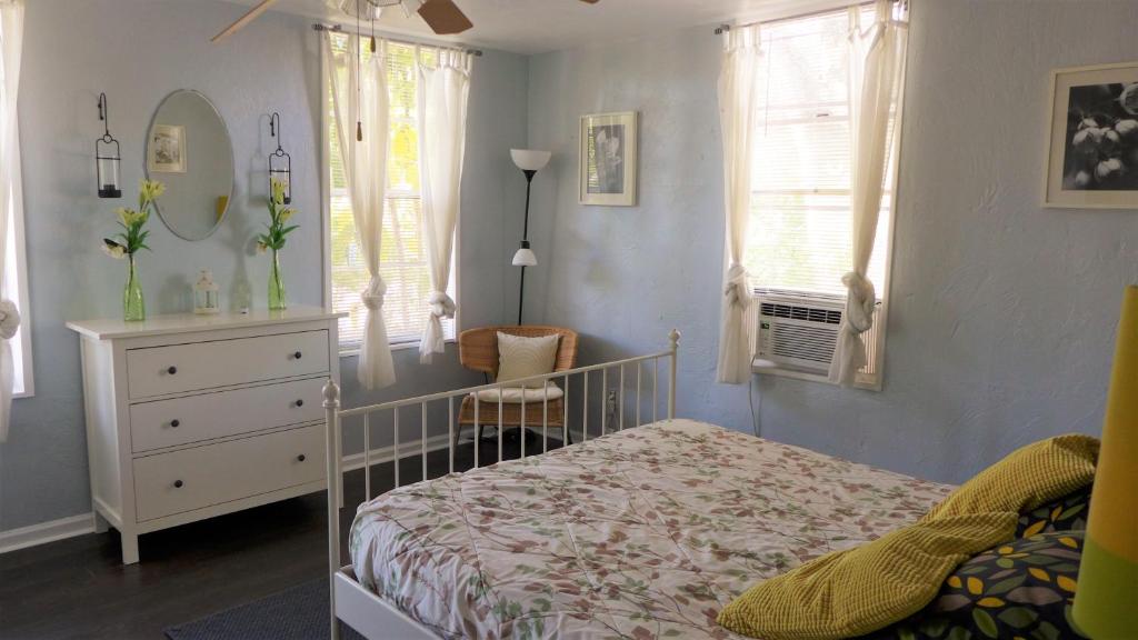 迈尔斯堡Barra Villa Resort House I的一间卧室配有一张床、梳妆台和窗户。
