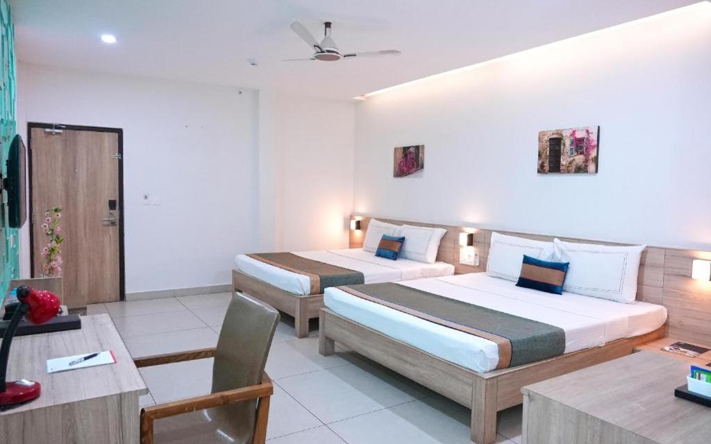 波隆纳鲁沃Suneetha Hotel的酒店客房设有两张床和一张桌子。