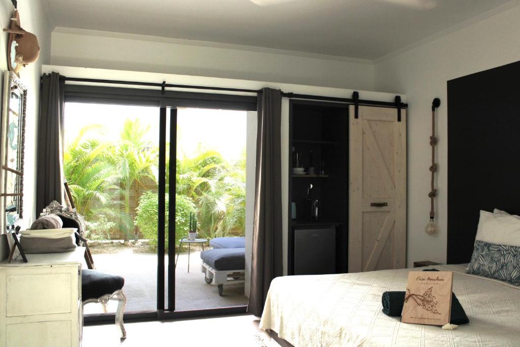 克拉伦代克Casa Mantana Bonaire的一间卧室设有一张床和一个滑动玻璃门