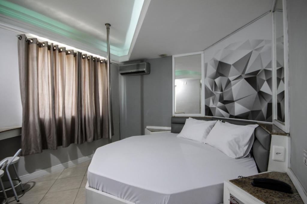 圣保罗Mirage Motel Guarulhos的卧室配有一张白色床和几何墙