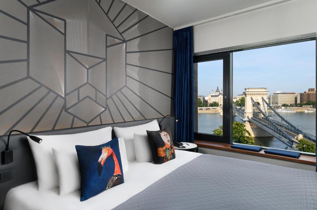 布达佩斯Hotel Clark Budapest - Adults Only的一间卧室设有一张床和一个带桥的窗户