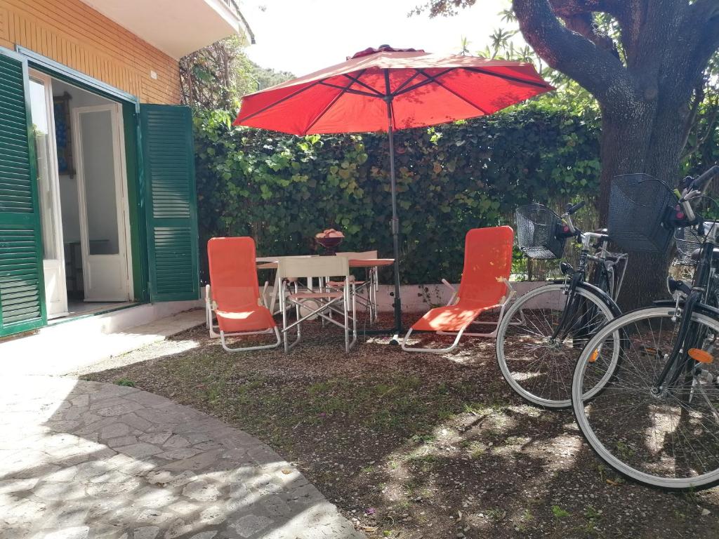弗雷杰内Vacanze degli Sposi的房屋旁配有遮阳伞的桌椅