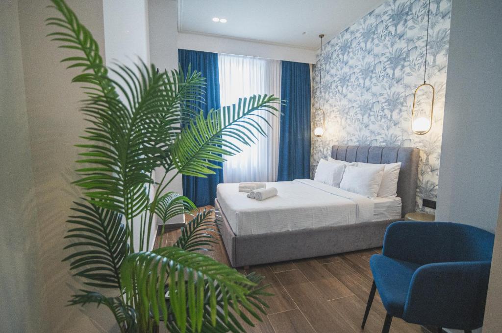 雅典Downtown Suites by Athens Tower Hotel的一间卧室配有一张床和盆栽植物