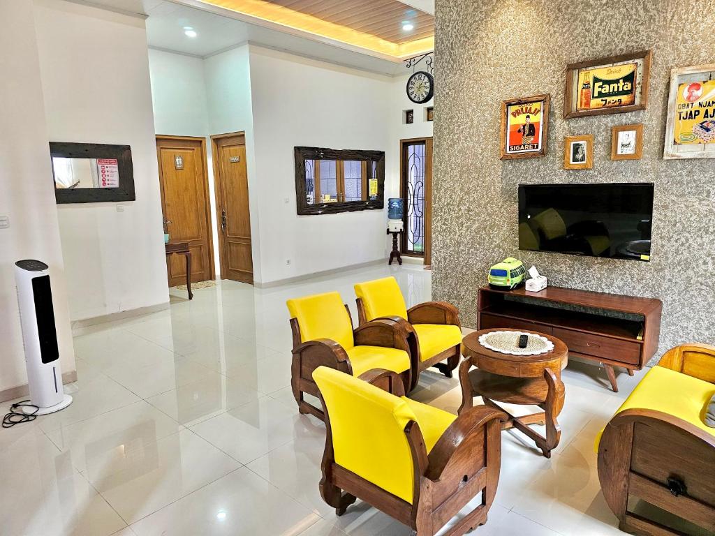 TimuranOmah Tabon Jogja - Dekat Dengan Malioboro的客厅设有黄色椅子和壁炉
