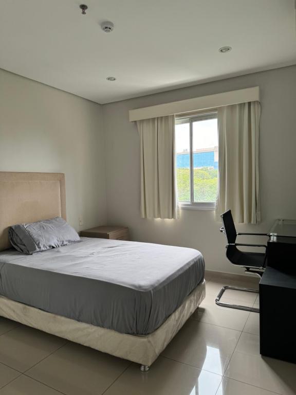 亚松森Luxury modern duplex apartment Villa Morra Asunción的卧室配有床、椅子和窗户。