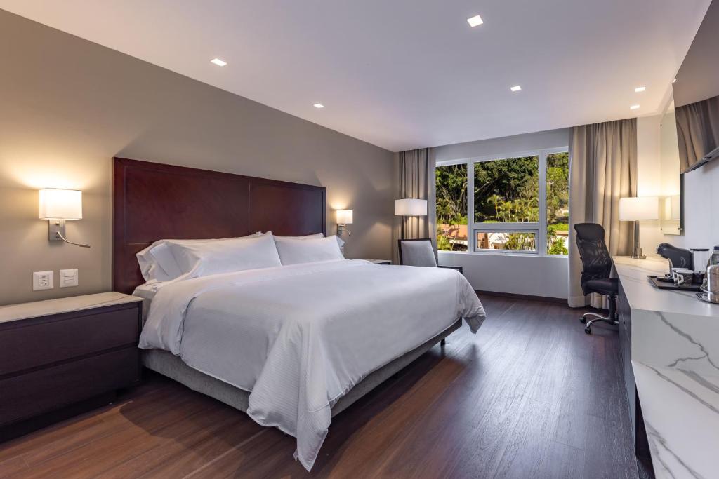 危地马拉比尔特莫酒店的卧室设有一张白色大床和一扇窗户。