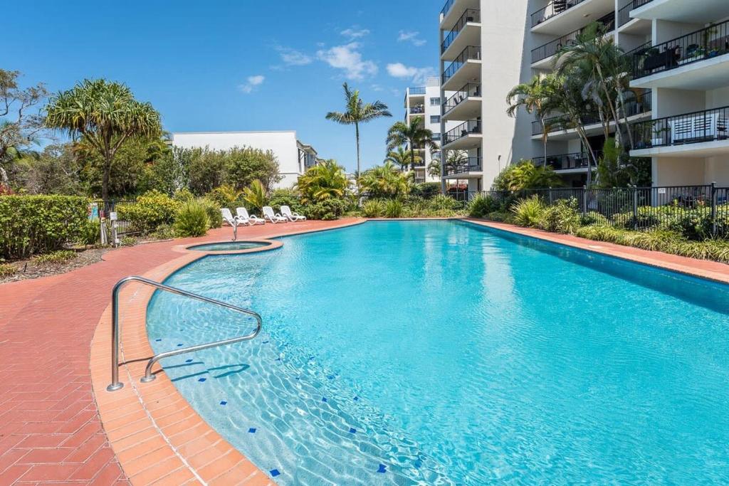 马库拉Beachfront Oasis with Private Rooftop Retreat的公寓大楼前的游泳池
